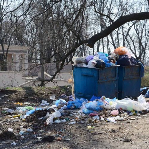 The garbage can is packed with garbage and waste. Untimely removal of garbage in populated areas